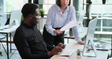 Meslektaşlar, bir ofis masasının etrafında toplanırken iş meseleleriyle ilgili verimli bir tartışmaya girişirler. İşbirlikçi yaklaşım dinamik bir ofis ortamına katkıda bulunur.