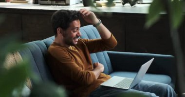 Orta Doğulu bir adam dizüstü bilgisayarıyla vakit geçirmeyi eğlenmeyi ve kahkahalarını paylaşmayı sever. Neşeli ifadesi teknolojinin verdiği hazzı ve rahatlığı yansıtıyor..