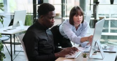 Çok ırklı bir girişimci ikilisi ofiste sorunsuz bir şekilde birlikte çalışıyor. Bu sahnede güçlü ortaklıkları ve iş amaçlarına ulaşma kararlılıkları gözler önüne seriliyor..