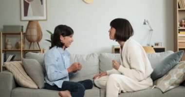 Kaygısız anne ve gülümseyen oğul oturma odasındaki kanepede dinlenirken neşeli ve neşeli bir anı paylaşırken birbirlerine beşlik çakıyorlar..