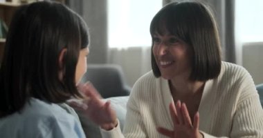 Beyaz tenli bir anne gibi konuşuyorlar ve oğullarını şefkatle kucaklıyorlar oturma odasındaki kanepede otururken, bir anlık sıcaklık ve şefkat paylaşıyorlar..