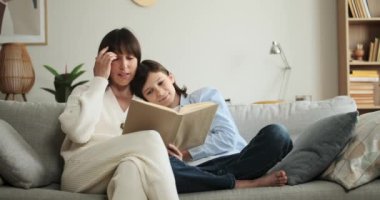 Anne ve oğlu, oturma odasında kanepede otururken kitap okuyarak birlikte güzel vakit geçirmenin keyfini çıkarıyorlar. Okumaya olan ortak aşkları özel ve zengin bir an yaratır..