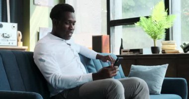 Kendine güvenen bir siyah adam video görüşmesi için telefondan faydalanıyor. Yerinden başkalarıyla sorunsuzca bağlantı kuruyor. Sanal bir sohbete girerken iletişim ve uyum sağlama kolaylığı açıkça görülüyor..