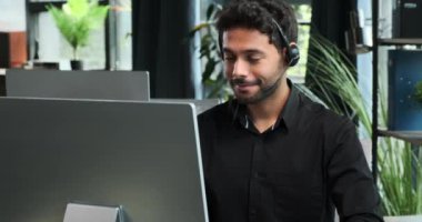 Memnuniyetle dolu Orta Doğulu işadamı, ofisteyken telefonla olumlu haberler alınmasını kutluyor. Sevinçli tepkisi, iş yerine nüfuz eden heyecanı yansıtıyor..