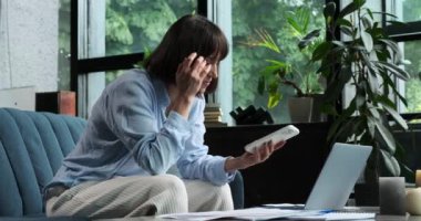 Kafkasyalı bir kadın koltukta telefonu kullanırken bir ilham anı yaşar. Yaratıcı bir içgörü sahnesinde yakalanan parlak bir fikri tasarlarken yüzü heyecanla parlıyor..