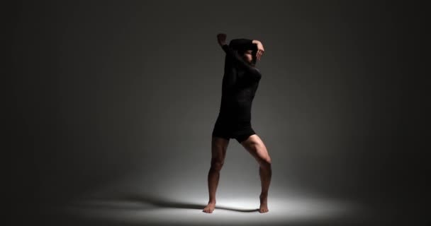 迷人的慢镜头捕捉了一个男人在醒目的对比灯光下的舞蹈表演 他优美的动作创造了视觉上迷人 艺术上丰富的体验 — 图库视频影像