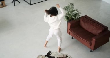 Dinamik kadın oturma odasını sınırsız enerjiyle dolduruyor, coşku ve enerjiyle dans ediyor. Animasyon hareketleri ve canlı performansı heyecan verici bir ortam yaratıyor..