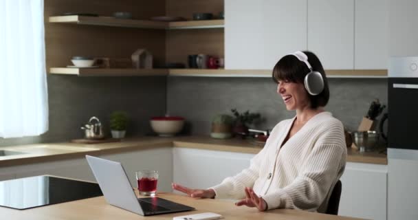一位快乐的白人妇女站在厨房时 通过视频通话与人分享欢笑和对话 她那富有传染性的喜悦给虚拟的互动增添了一种积极的气氛 — 图库视频影像