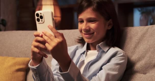 Mladý Chlapec Sedí Pohovce Obličej Zdobený Smíchem Když Komunikuje Telefonem — Stock video