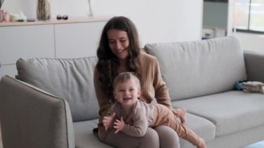 Sevgiyle dolu genç bir anne, kanepede oğluyla eğlenceli aktivitelere girişir. Gülüşmeler ve hassas anlar paylaşıyorlar, anne şefkatinin ve çocukluk sevincinin iç açıcı bir sahnesini yaratıyorlar..