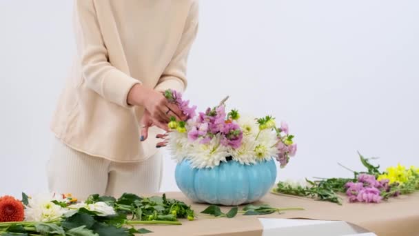 Fleuriste Caucasien Qualifié Conçoit Méticuleusement Bouquet Intérieur Une Citrouille Creuse — Video