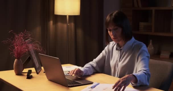 Kobieta Kontynuuje Pracę Domu Otoczona Papierami Laptopem Pomieszczenie Skąpane Jest — Wideo stockowe
