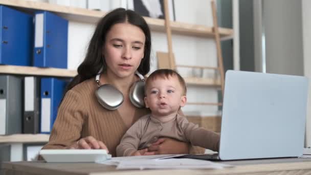Toegewijde Moeder Behendig Beheert Werk Laptop Terwijl Cradling Zoete Baby — Stockvideo