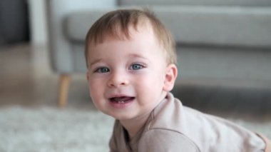 Bebek yerde sürünüyor, gözleri merakla dolu. Her hareket bir maceradır ve oda kıkırdama sesiyle yankılanır. Bu iç açıcı portre ilk keşiflerin özünü yansıtıyor..