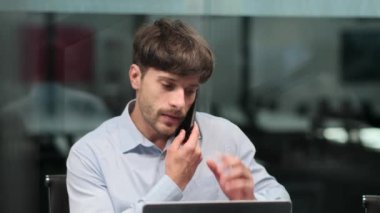 Ciddi bir adam çift görevi yönetir, ofiste kağıtları sıralarken telefonda dikkatlice konuşur. Yoğunlaştırılmış ifade ve hızlı hareketler hem iletişim hem de organizasyona bağlılığın altını çizer.