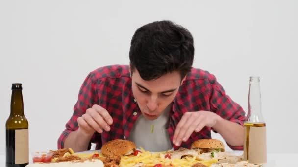 Zdeterminowany Biały Mężczyzna Siedzi Przy Stole Szybko Spożywając Fast Food — Wideo stockowe