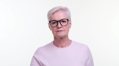 Huzurlu yaşlı kadın, bir uyarı jesti olarak parmağını sıkarken sert bir ifade takınır. Kararlı bakışları otoriteyi ve bilgeliği yansıtıyor. Kararlılığını ve ciddiyetini yansıtıyor..
