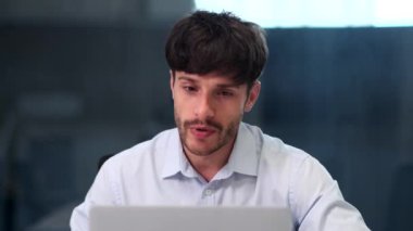 Video konferansın kapanış anlarında bir işadamı sıcak bir gülümseme ve şükranla veda eder. Mesleki davranışlar ve kibar jestler meslektaşlarına olan saygıyı yansıtıyor.