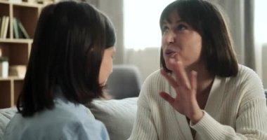 Mutlu anne, oğluyla koltuğun oturma odasında samimi bir konuşma yapar. Etkileşimleri güçlü ve sevgi dolu bir aile bağını yansıtıyor..