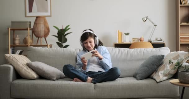 Enerjik Bir Çocuk Kulaklık Takıyor Telefonda Hevesle Çalıyor Oyuna Uygulamaya — Stok video