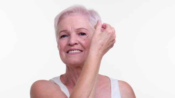 Composé Femme Caucasienne Senior Distribue Délicatement Lotion Faciale Sur Peau — Video