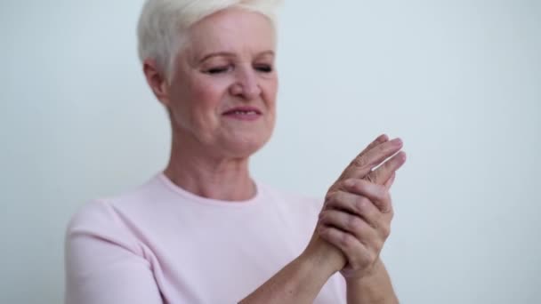 Die Lächelnde Kaukasische Seniorin Trägt Zärtlich Handcreme Auf Die Hände — Stockvideo
