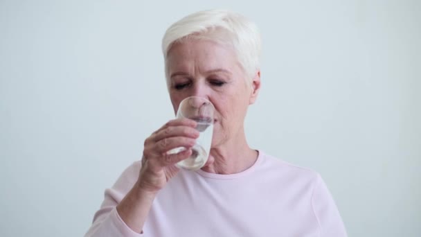 Ώριμη Λευκή Γυναίκα Πίνει Μια Γουλιά Νερό Από Ένα Ποτήρι — Αρχείο Βίντεο