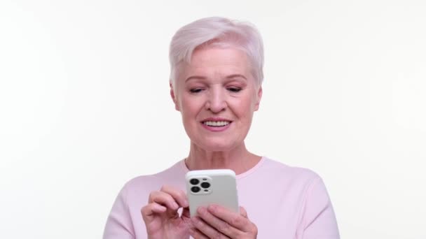 Nöjda Äldre Kaukasiska Kvinna Använder Lätt Smartphone Hennes Ögon Glimmar — Stockvideo