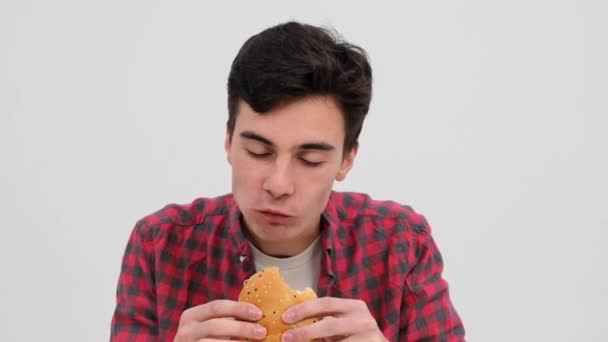 Běloch Pochutnává Slaném Hamburgeru Oči Září Kulinářským Potěšením Pozadí Čistého — Stock video