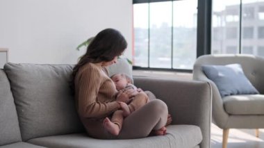 Evinin sessiz kucağında, sevgi dolu bir anne, küçük oğlunu kucağına alır, ona kucak dolusu yiyecek sunar. Gözler şefkatle doludur ve oda emzirme sesiyle doludur..