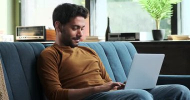 Orta Doğulu bir adam video aracılığıyla iletişim kurarken el sallıyor. Onun dostane jesti, insan ilişkilerinin değerini vurgulayarak sanal sohbete kişisel bir dokunuş ekliyor..