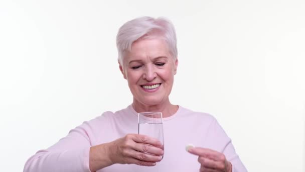 Starsza Kobieta Ostrożnie Wrzuca Musującą Tabletkę Szklanki Wody Jej Skupiona — Wideo stockowe