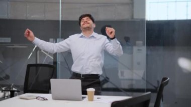 Zevkli adam ofiste dizginlenemez bir neşeyle dans ediyor. Yüzü bulaşıcı bir gülümsemeyle ışıldıyor ve hareketler enerji ve coşku yayıyor. Ofis alanı canlı dansla canlanıyor..