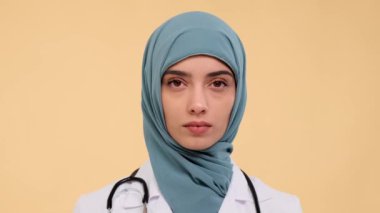 Arap bir kadın doktora komuta etmek profesyonellik ve kendini bej arkaplana adamak, sağlık hizmetleri pratisyeni rolündeki yerçekimini ve sorumluluğunu yakalamak demektir..