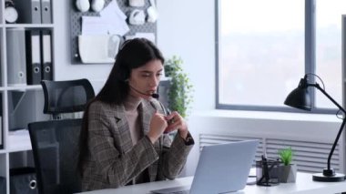 Ofisteki odaklanmış bir kadın telefon görüşmesi sırasında sohbet eder. Bu görüntü, ofis ortamında iletişim kurarken sergilediği profesyonel ve özenli tavrı yansıtıyor..