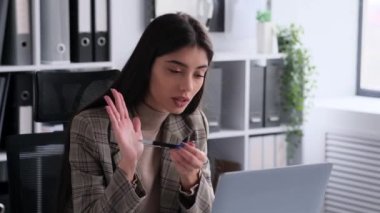 Saldırganlık anında, kararlı bir beyaz kadın ofis masasındaki bir video görüşmesi sırasında kızgınlığını dile getirir. Bu yoğun görüntü iddialı ve güçlü doğayı yakalar..