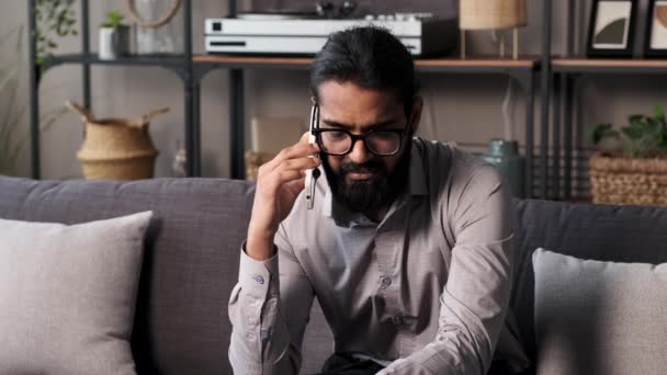 Χαμογελώντας Ινδός Άντρας Συμμετέχει Μια Τηλεφωνική Συνομιλία Ενώ Κάθεται Στον — Αρχείο Βίντεο