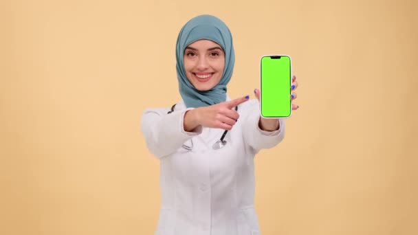 Doctora Árabe Muestra Con Confianza Teléfono Con Una Pantalla Verde — Vídeo de stock