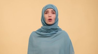Üzüntülü Arap kadın hüzünlü bir ruh halini bej bir arka plana karşı dokunaklı bir portrede yansıtıyor, derin düşüncelere dalmış bir ortamda ham duygu ve hassasiyeti aktarıyor..
