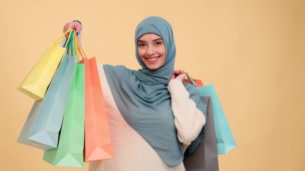 Mulher Árabe Apresenta Sacos Compras Uma Exibição Confiante Contra Fundo — Vídeo de Stock