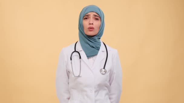 Arabiska Kvinnliga Läkare Speglar Sorg Och Besvikelse Mot Dämpad Beige — Stockvideo