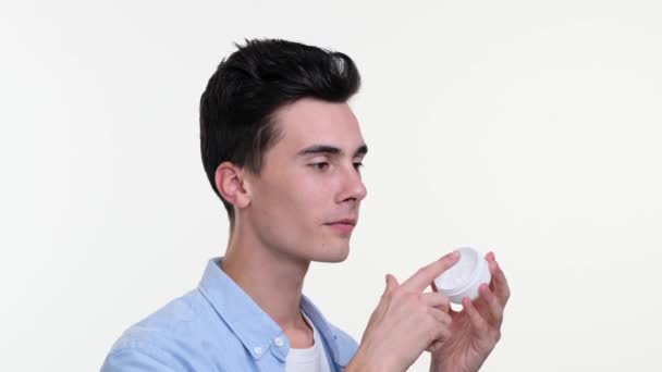 Close Portrait Smiling Caucasian Young Man Applying Facial Cream Isolated — Stock Video