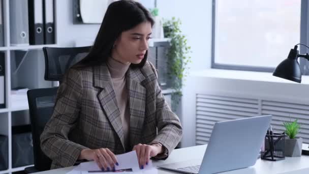 文書とラップトップを持つオフィスでの慎重な女性の従業員会計業務 会社の投資と予算のチェック 書類の見直し — ストック動画