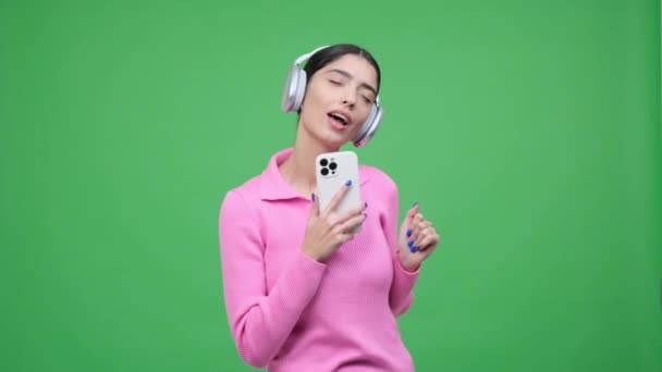 Щаслива Усміхнена Кавказька Жінка Слухає Музику Навушниках Співає Разом Телефоном — стокове відео