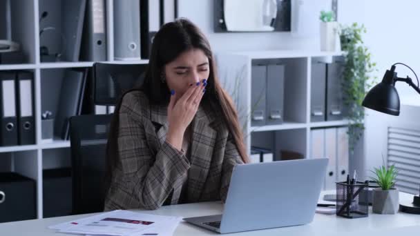疲惫的白人女人在办公室用笔记本电脑工作 打呵欠和伸懒腰 劳累和劳累的概念 — 图库视频影像