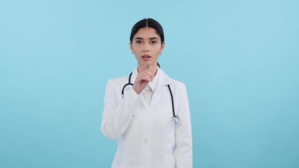 Poważny Kaukaski Lekarz Lub Pielęgniarka Wykazujący Cichy Gest Niebieskim Tle — Wideo stockowe