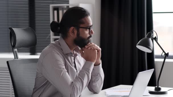 Přemýšlivý Indický Manažer Pracující Kanceláři Notebookem Zatímco Sedí Stolu Přemýšlí — Stock video