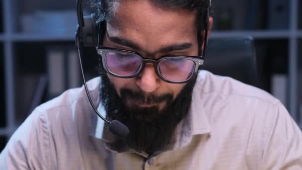快乐的印度男性在线支持专业员工在晚上的办公室里用耳机随叫随到 客户在线协助 呼叫中心操作员工作 — 图库视频影像