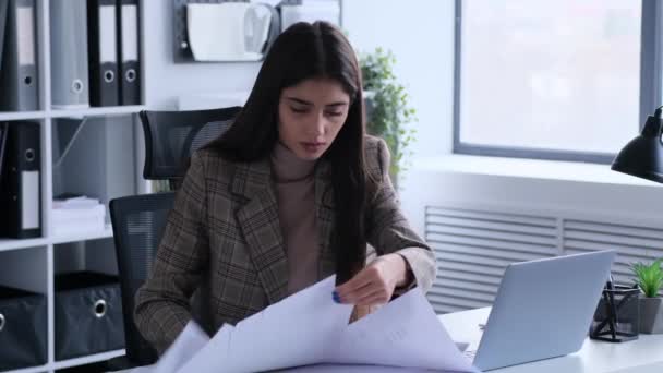 オフィスの机に座って書類を急いでいる白人の若い女性 ハイワークロード ドキュメント検索 オフィスカオスコンセプト — ストック動画
