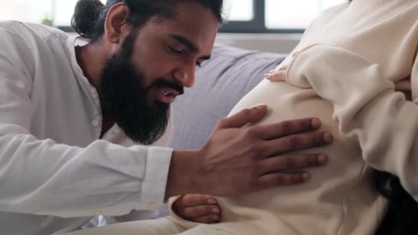 Vrolijke Indiase Man Praten Met Vrouw Zwanger Buik Zachte Strelen — Stockvideo